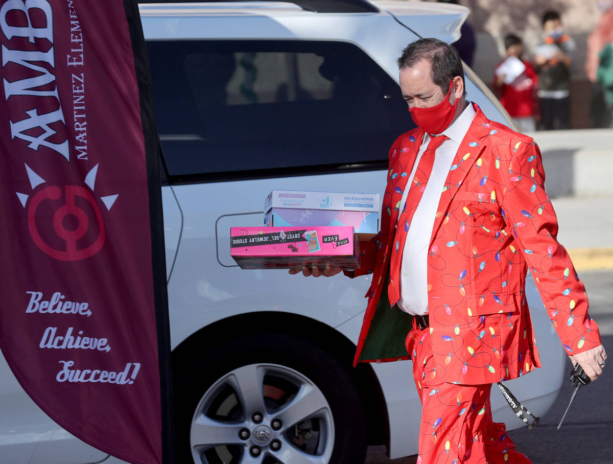 Principal Timothy Adams delivers gifts at Martinez Elementary School in North Las Vegas Thursda ...