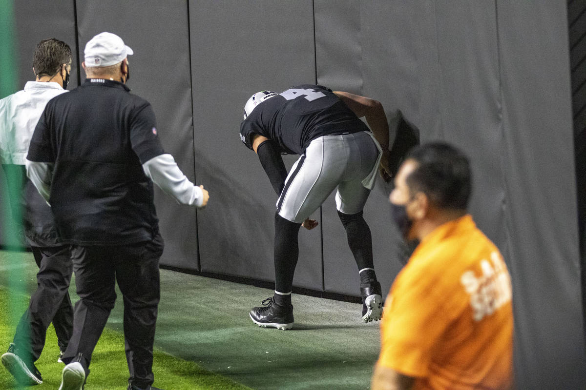 Raiders quarterback Derek Carr (4) bends over after injuring his groin on a run during the firs ...