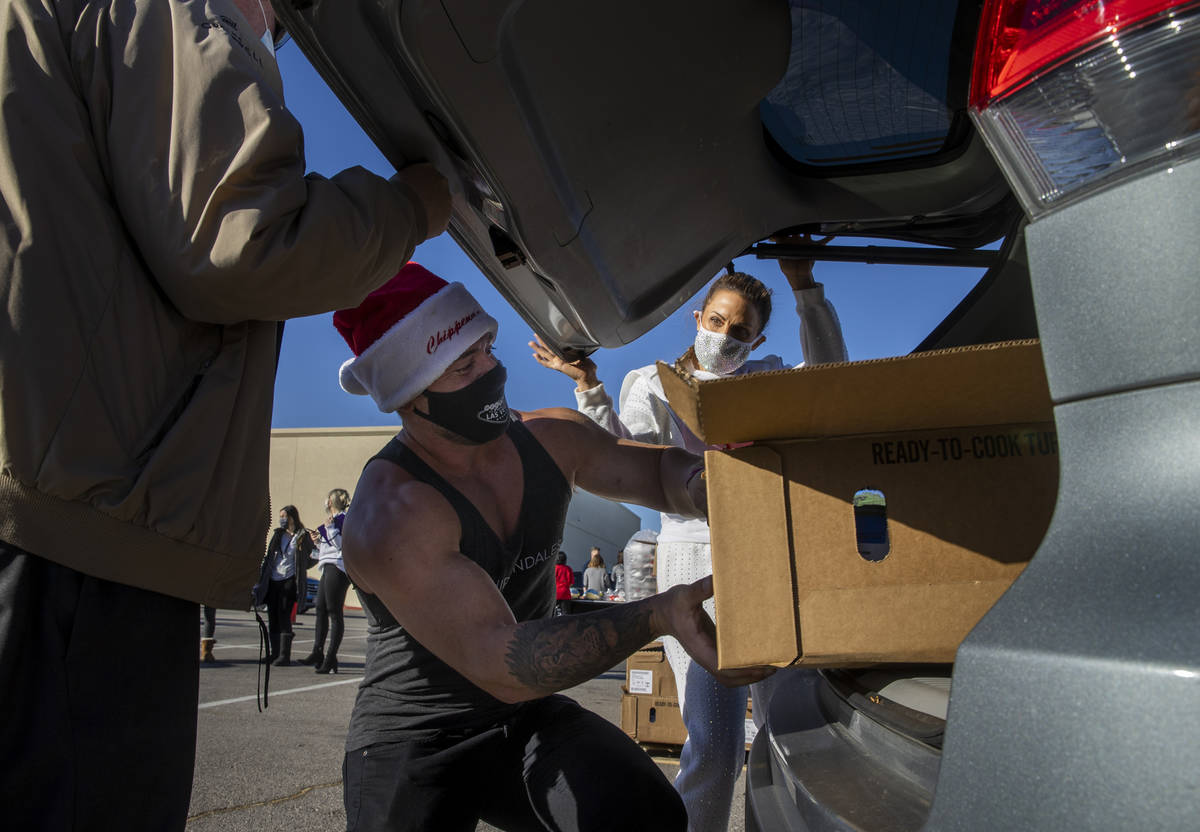 Chippendales member Ryan Worley loads up turkeys and cookies to an awaiting vehicle during the ...