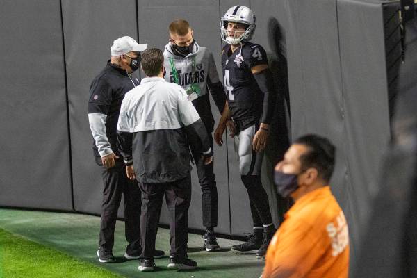 Raiders quarterback Derek Carr (4) is attended to by trainers after injuring his groin on a run ...