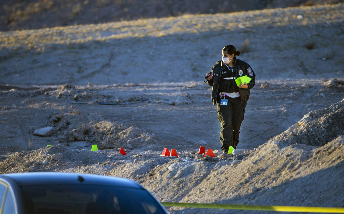 Lettered evidence markers are placed as North Las Vegas Police investigate a homicide along Wes ...