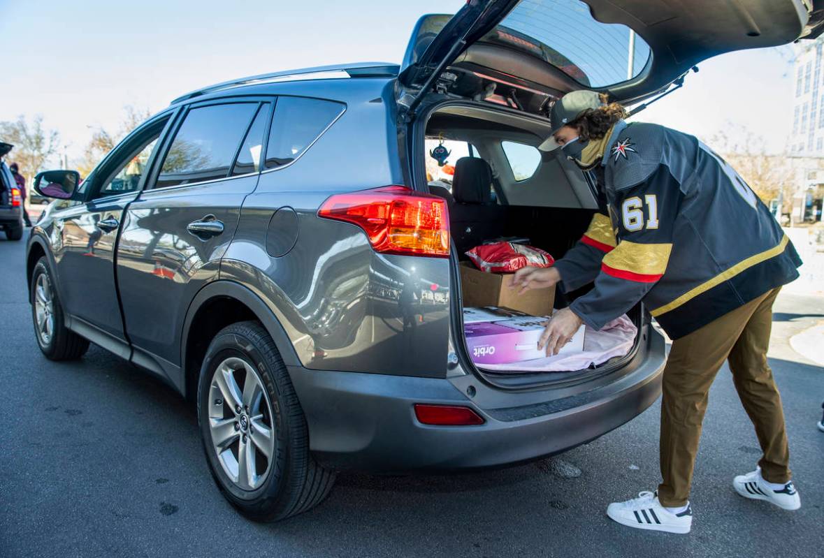 Golden Knights player Mark Stone loads up gifts during the first NLVPD Holiday Toy Giveaway dri ...
