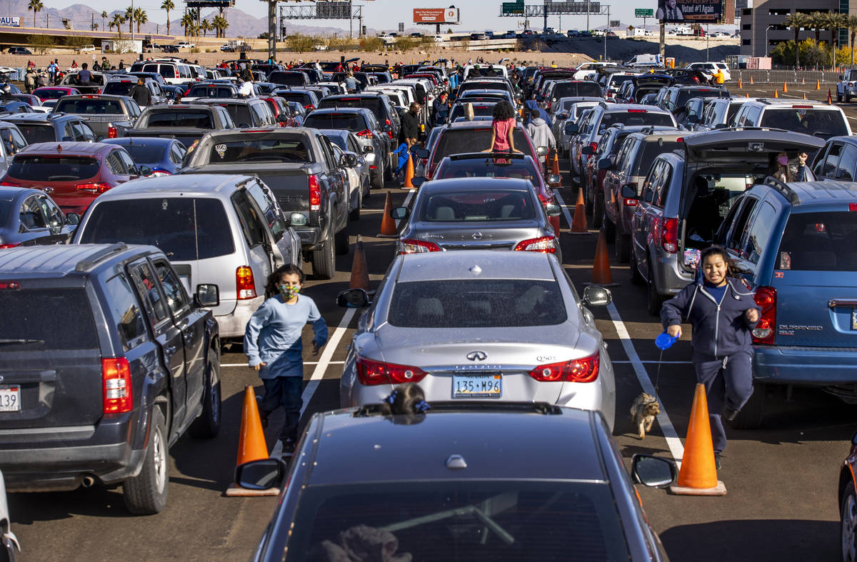 Hundreds of drivers and passengers wait in the World Market parking lot as the Las Vegas Rescue ...