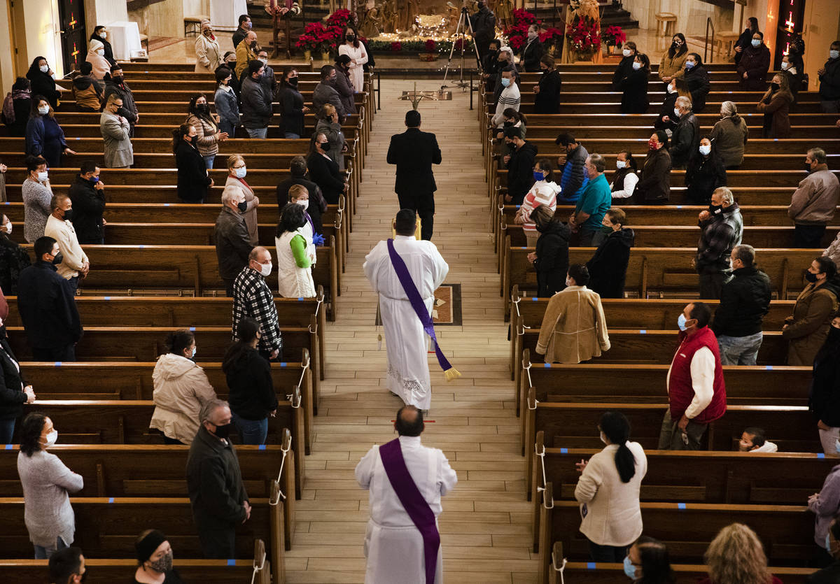 Deacons head towards the front of the church preceding Mass at St. Anne's Catholic Church in La ...