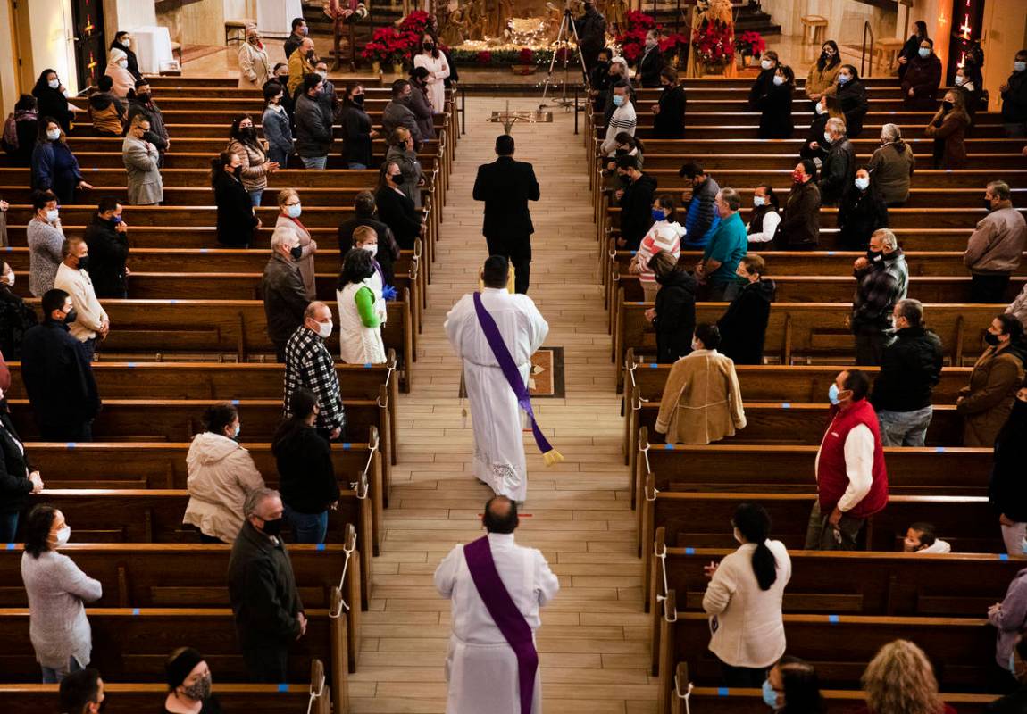 Deacons head towards the front of the church preceding Mass at St. Anne's Catholic Church in La ...
