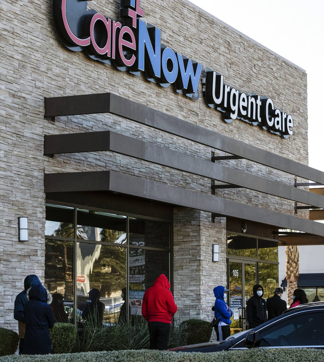 People line up outside of CareNow Urgent Care at 7040 South Durango Drive, on Tuesday, Dec. 22, ...