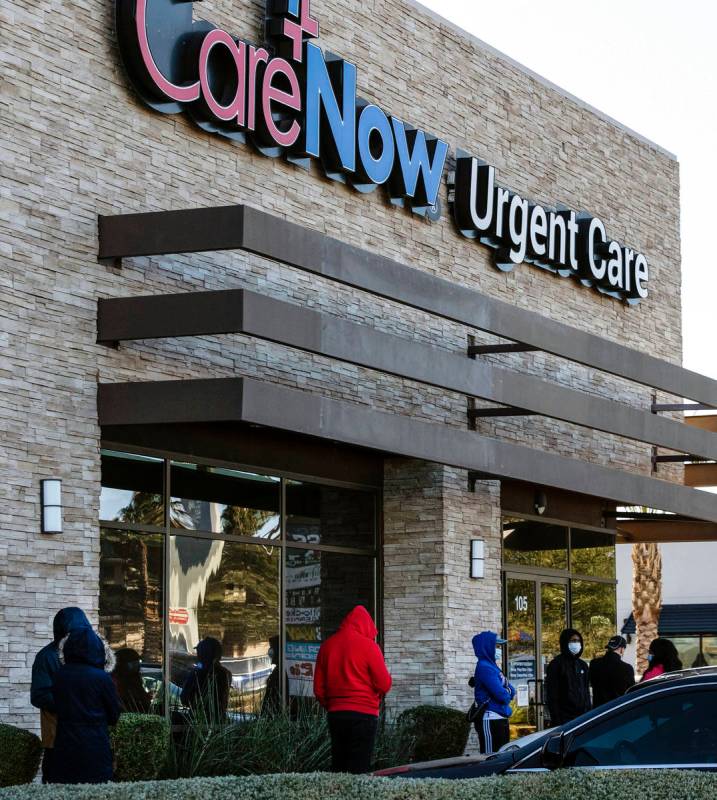 People line up outside of CareNow Urgent Care at 7040 South Durango Drive, on Tuesday, Dec. 22, ...
