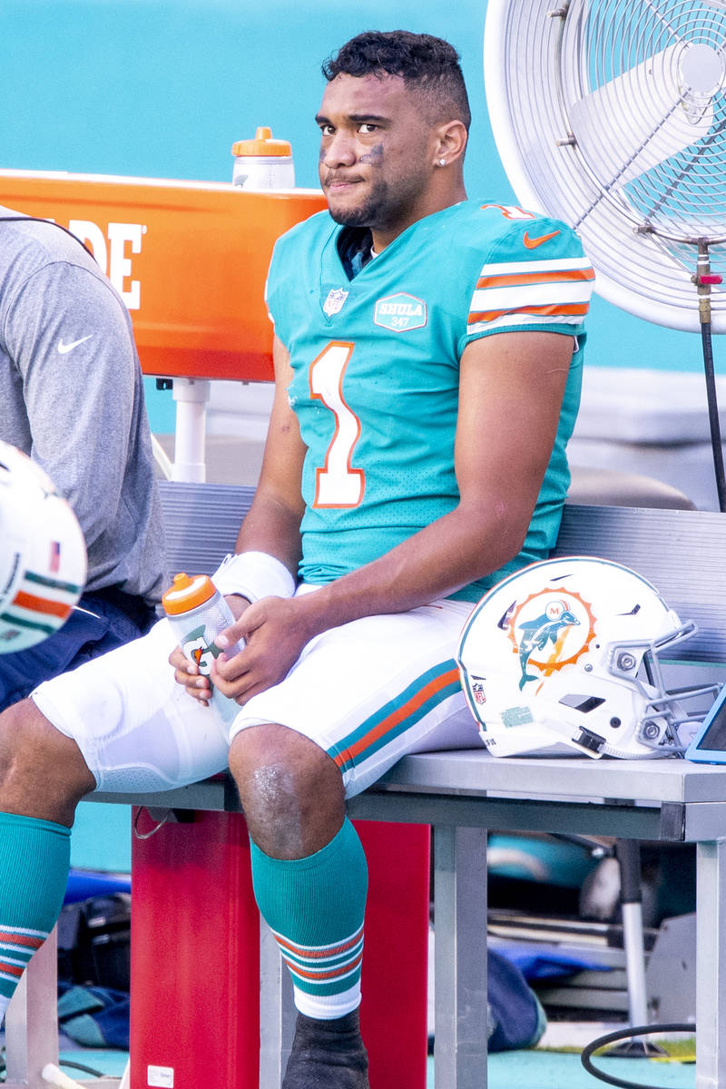 Miami Dolphins quarterback Tua Tagovailoa (1) sits on the bench on the sidelines as the Dolphin ...