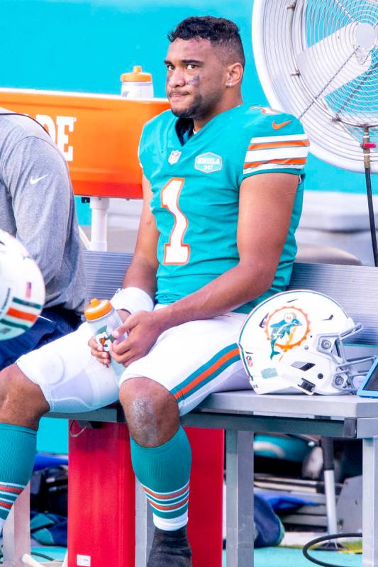 Miami Dolphins quarterback Tua Tagovailoa (1) sits on the bench on the sidelines as the Dolphin ...