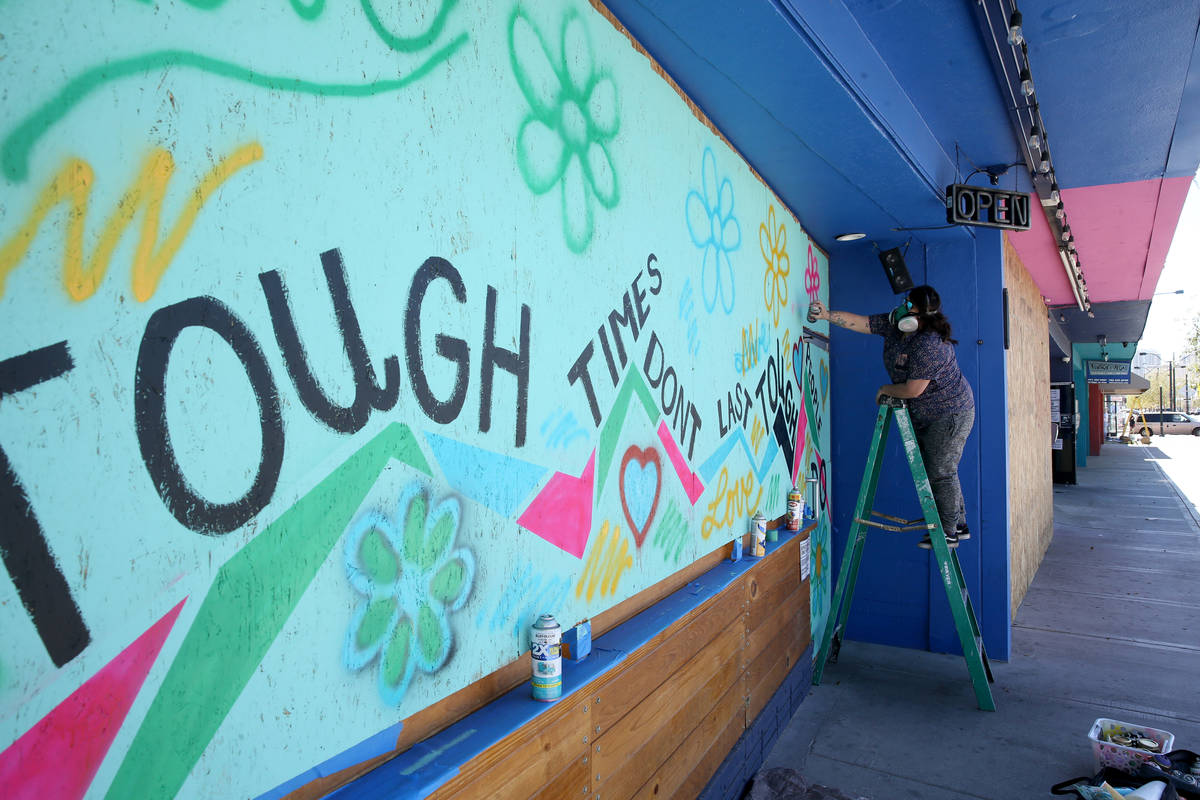 Artist Geneva Marquez paints a mural on the boarded up windows and door of Davey's @ReBar in th ...