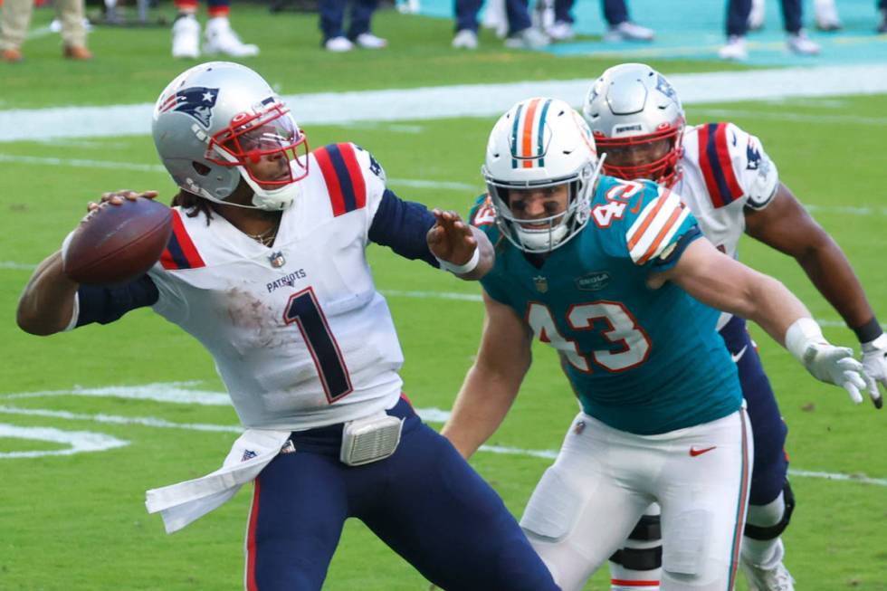 New England Patriots quarterback Cam Newton (1) aims a pass as Miami Dolphins outside linebacke ...