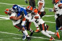 New York Giants running back Wayne Gallman (22) is tackled by Cleveland Browns defensive end Ol ...