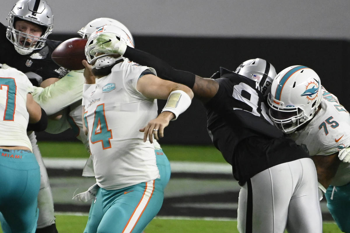 Las Vegas Raiders defensive end Arden Key (99) commits a roughing the passer penalty on Miami D ...