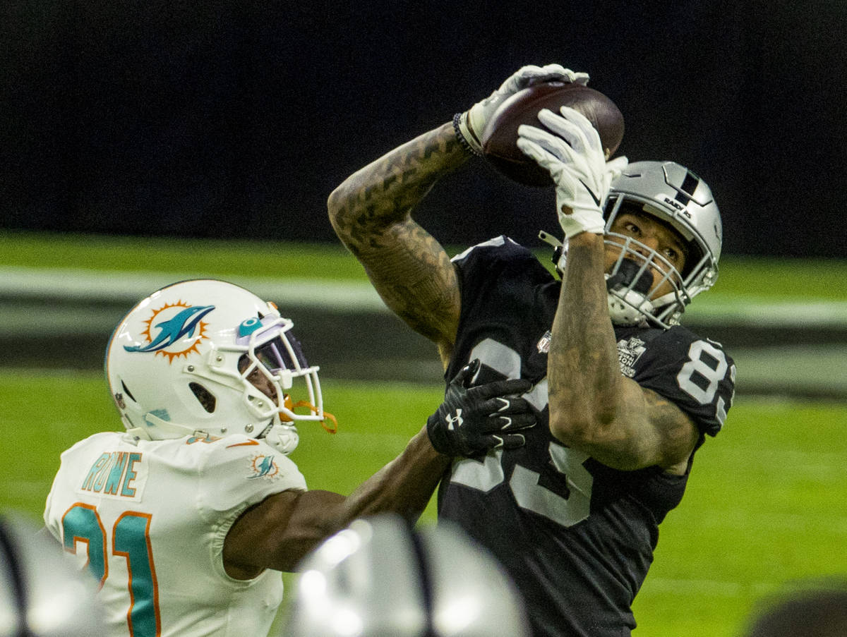 Raiders tight end Darren Waller (83) makes a long reception over Miami Dolphins free safety Eri ...
