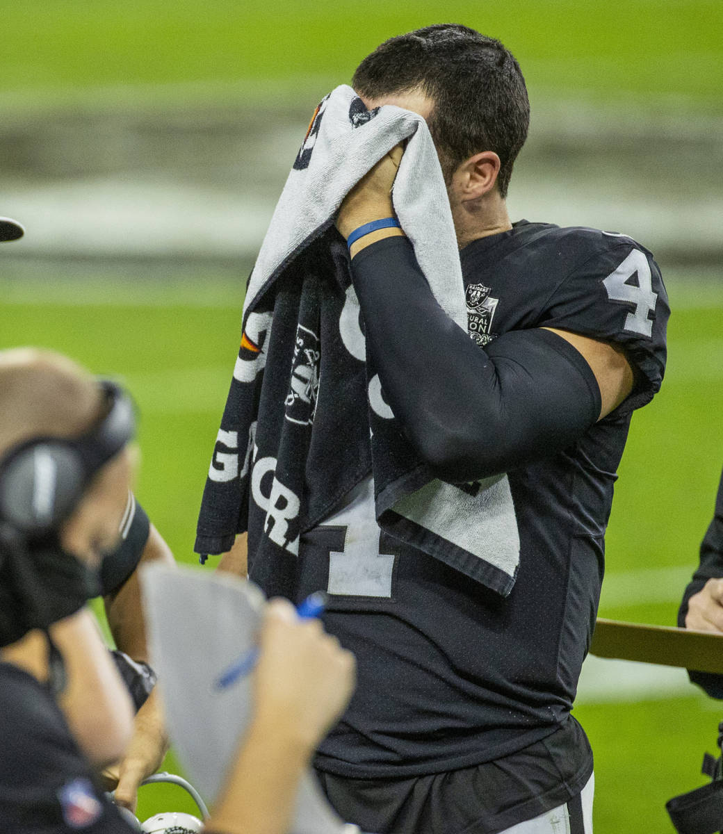 Raiders quarterback Derek Carr (4) puts a towel over his face on the sidelines versus the Miami ...