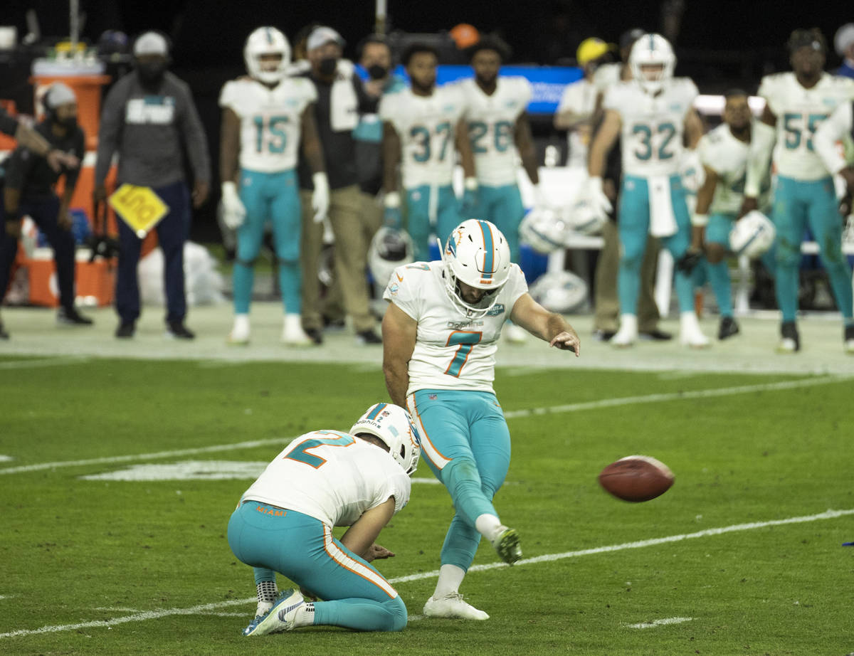 Miami Dolphins kicker Jason Sanders (7) kicks the winning extra point with a hold by teammate p ...