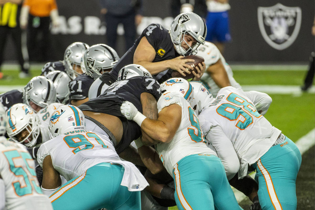 Raiders quarterback Derek Carr (4) goes over the top of the pile for a touchdown versus the Mia ...