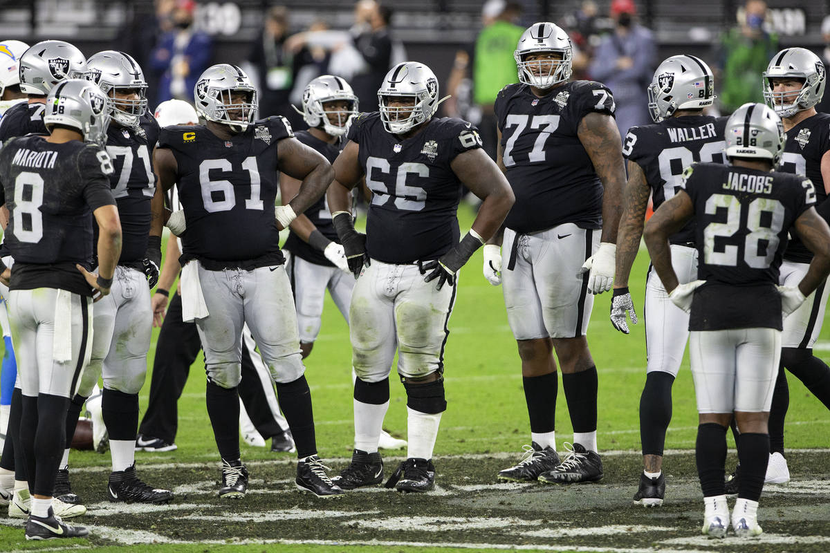 Raiders players convene between plays in the fourth quarter during an NFL football game on Thur ...