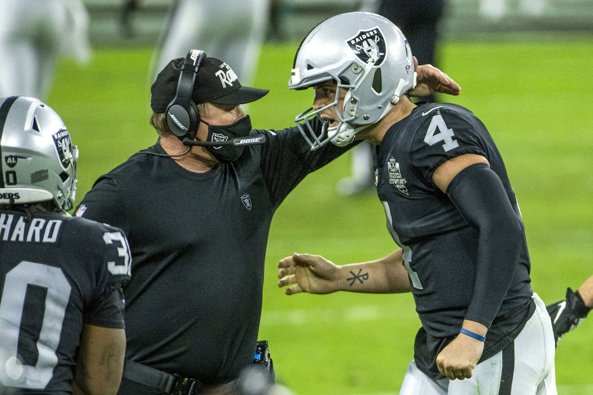 Raiders head coach Jon Gruden comes together on the sidelines with Raiders quarterback Derek Ca ...