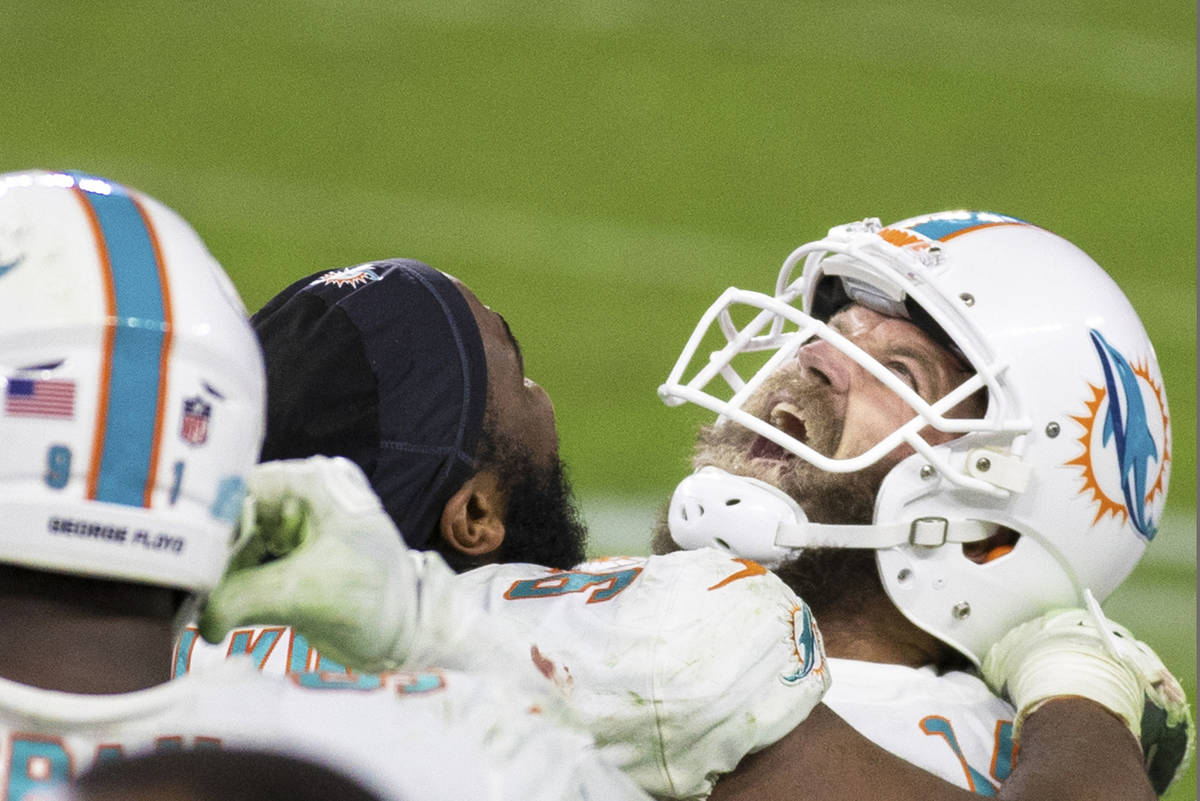 Miami Dolphins quarterback Ryan Fitzpatrick, right/top, celebrates with teammates after Miami k ...