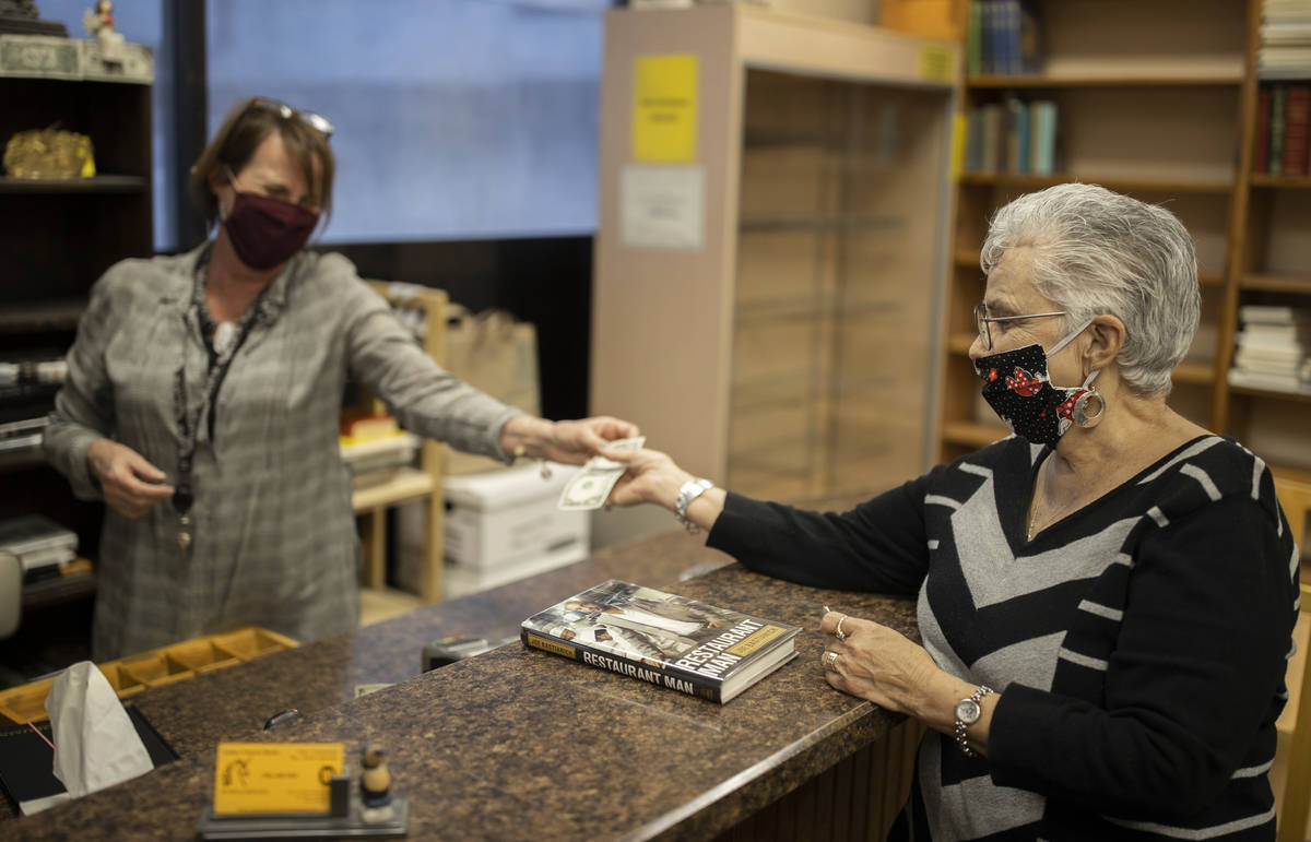 Myrna Donato, right, owner of Amber Unicorn Books, buys the last book before the Vegas landmark ...