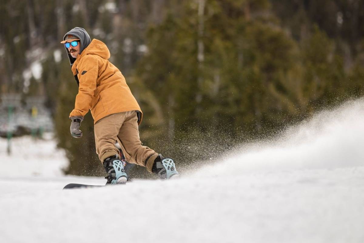 Snowboarder Ian Ryan of Las Vegas glides down the run near the lodge during opening day of skii ...