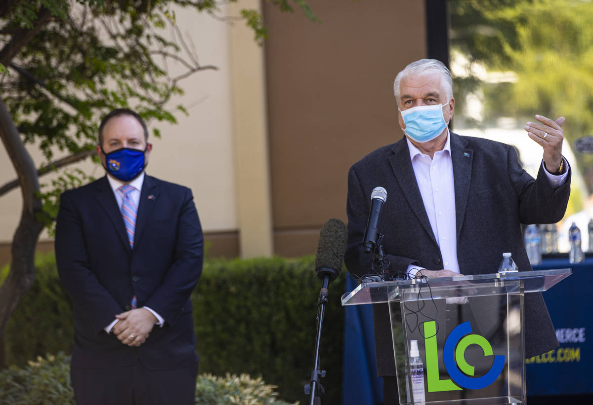 Gov. Steve Sisolak, right, speaks alongside Nevada State Treasurer Zach Conine during a press c ...