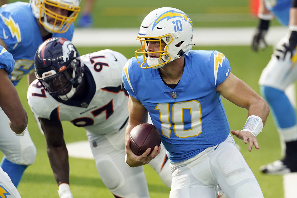 Los Angeles Chargers quarterback Justin Herbert (10) runs against the Denver Broncos during the ...
