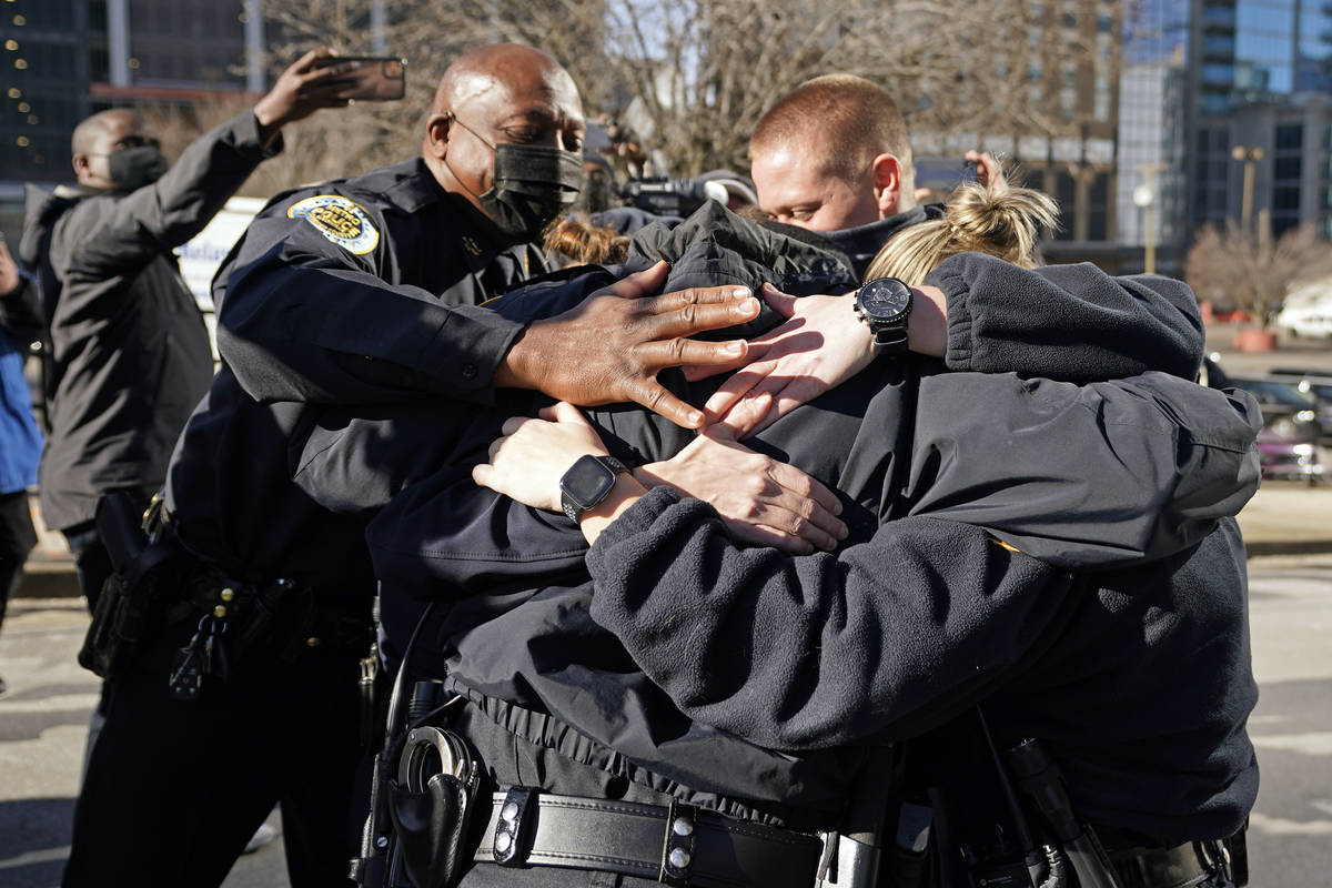 Nashville Police Chief John Drake, left, joins a group of police officers as they embrace after ...