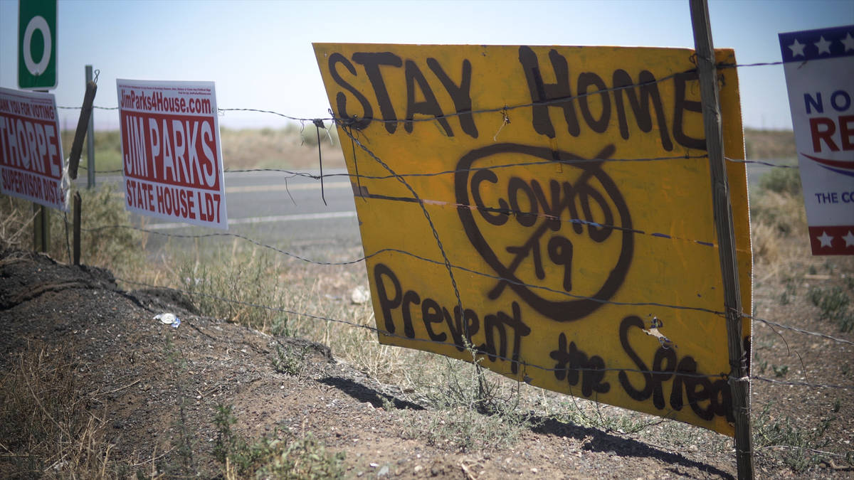 Makeshift, spray-painted signs at the entrance of the Navajo reservation warn visitors and Nava ...