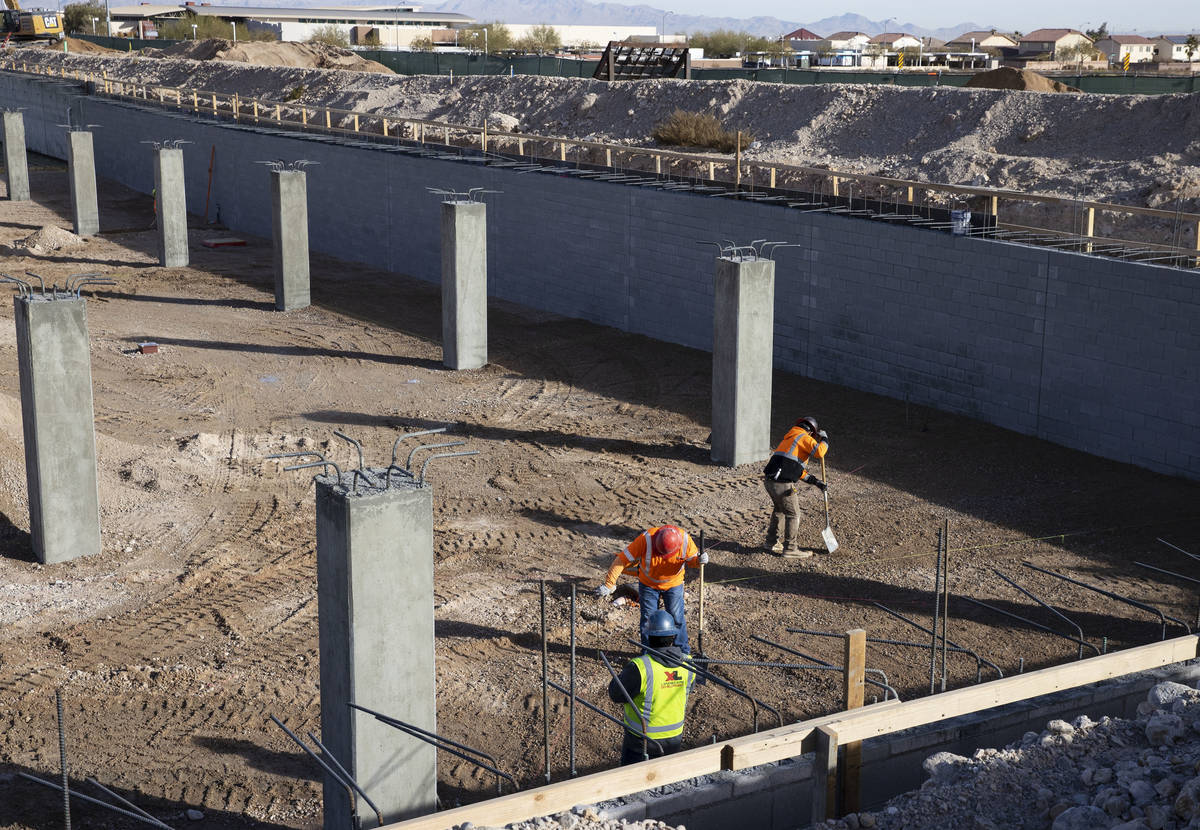 Construction workers at an underground parking garage at the Evora apartment complex site where ...