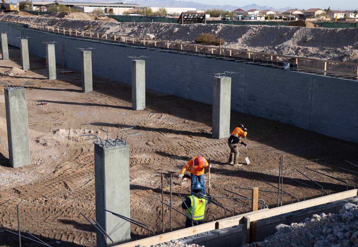 Construction workers at an underground parking garage at the Evora apartment complex site where ...