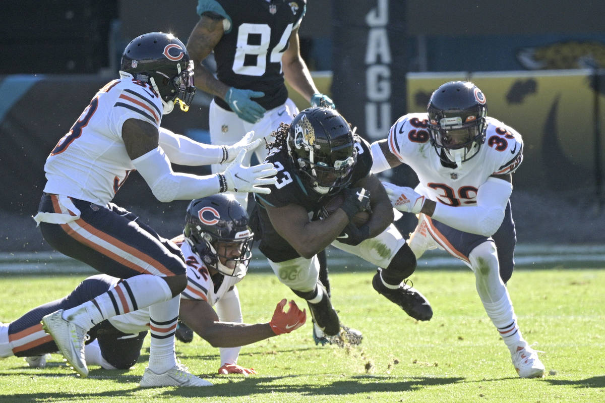 Jacksonville Jaguars running back Dare Ogunbowale (33) is tackled by Chicago Bears safety Tasha ...
