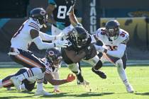 Jacksonville Jaguars running back Dare Ogunbowale (33) is tackled by Chicago Bears safety Tasha ...