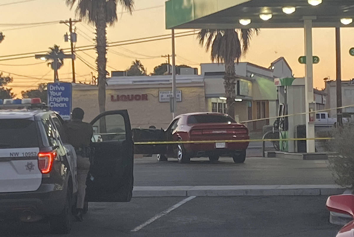 Las Vegas police surround a red Dodge car in front of a Sinclair gas station shortly after 6:30 ...