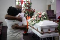 Darryl Hutchinson, facing camera, is hugged by a relative during a funeral service for Lydia Nu ...