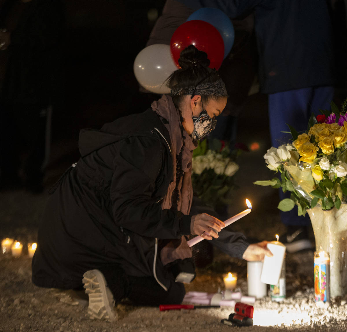 Krisztina Bessenyei lights candles at a vigil for Eric Echevarria, a 52-year-old father and hus ...