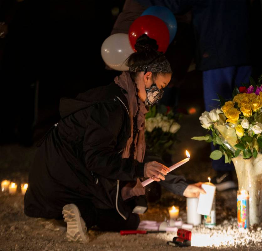 Krisztina Bessenyei lights candles at a vigil for Eric Echevarria, a 52-year-old father and hus ...
