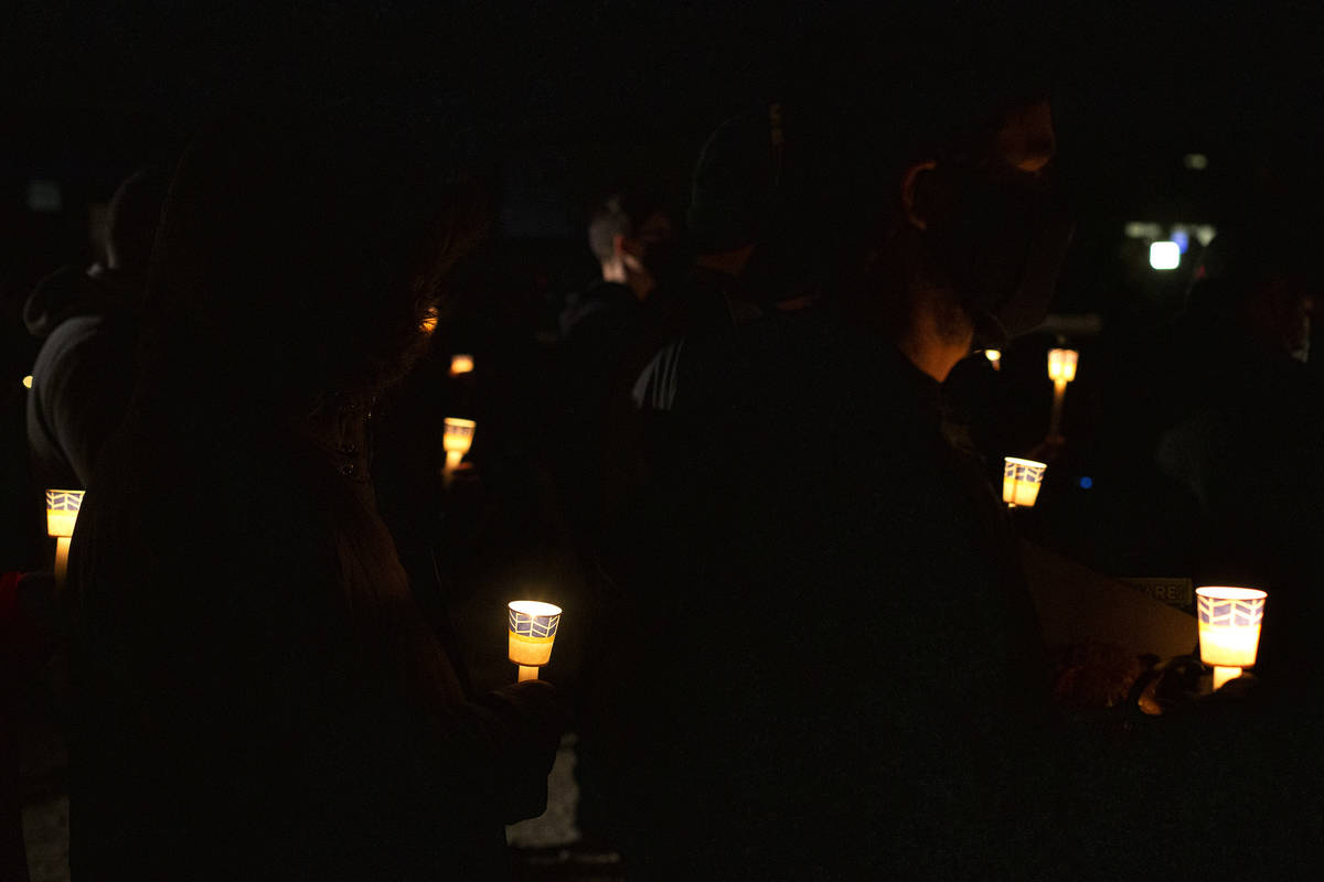 A crowd holds candles in honor of Eric Echevarria, a 52-year-old father and husband who was kil ...