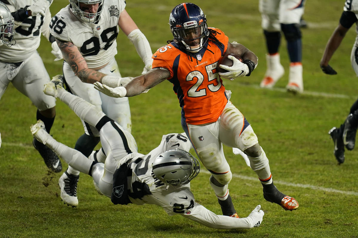 Denver Broncos running back Melvin Gordon (25) avoids a tackle by Las Vegas Raiders strong safe ...