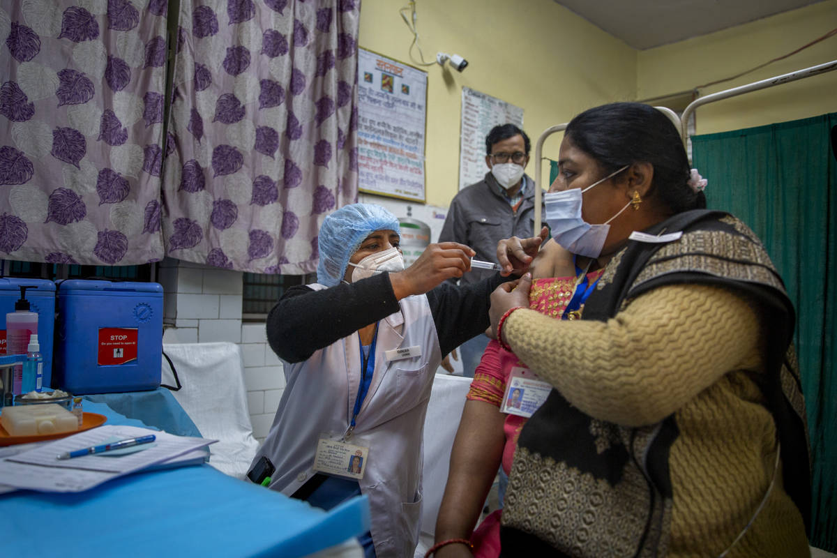 A health worker engages in a COVID-19 vaccine delivery system trial in New Delhi, India, Saturd ...