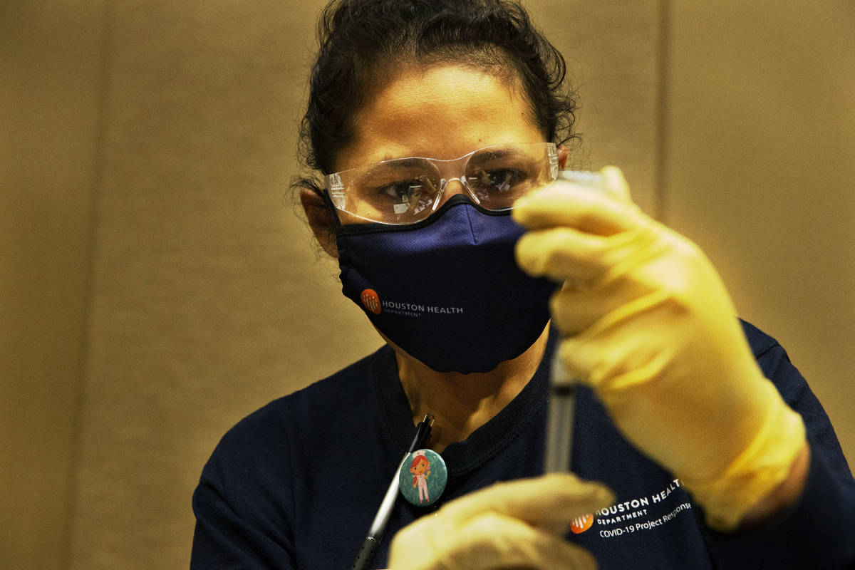 Houston Health Department LVN Alicia Meza prepares a dose of COVID-19 vaccine Sunday, Jan. 3, 2 ...