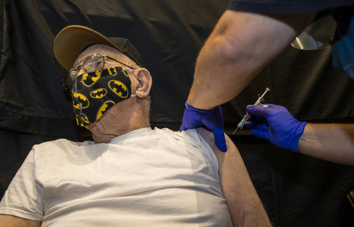 Veteran Lauren Matejka receives a shot from RN Darrel Cowlishaw as some of the first veterans l ...