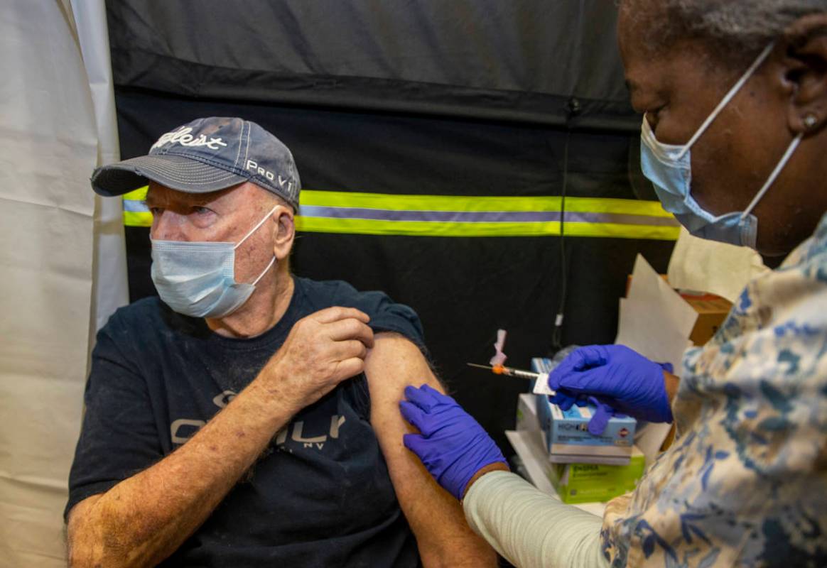 Veteran Jack Daughtrey, left, receives a shot from RN Francine Jones-Toliver as some of the fir ...