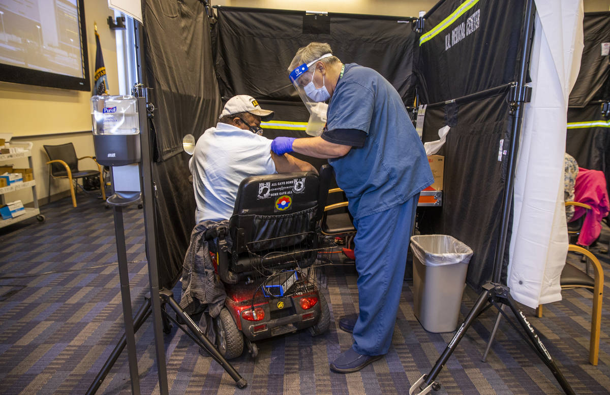 Veteran Levi Williams, left, is patched up after receiving a shot from RN Darrel Cowlishaw as s ...