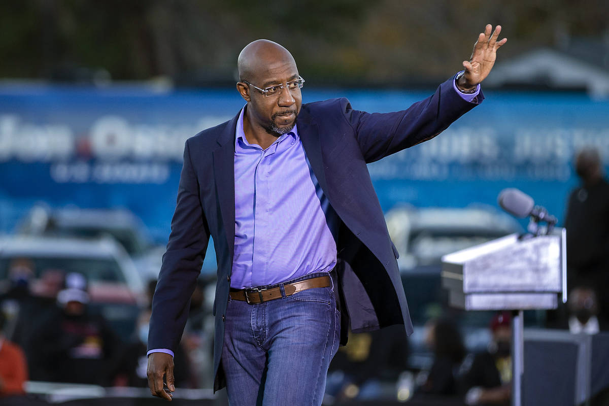 Democratic U.S. Senate candidate Rev. Raphael Warnock waves to supporters during a drive-in ral ...