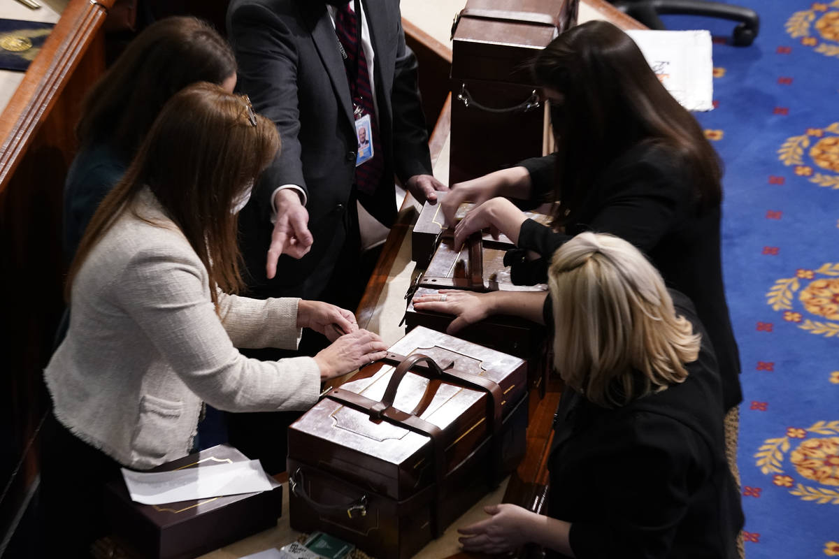 Staff members close boxes containing Electoral College votes after an objection to confirming v ...