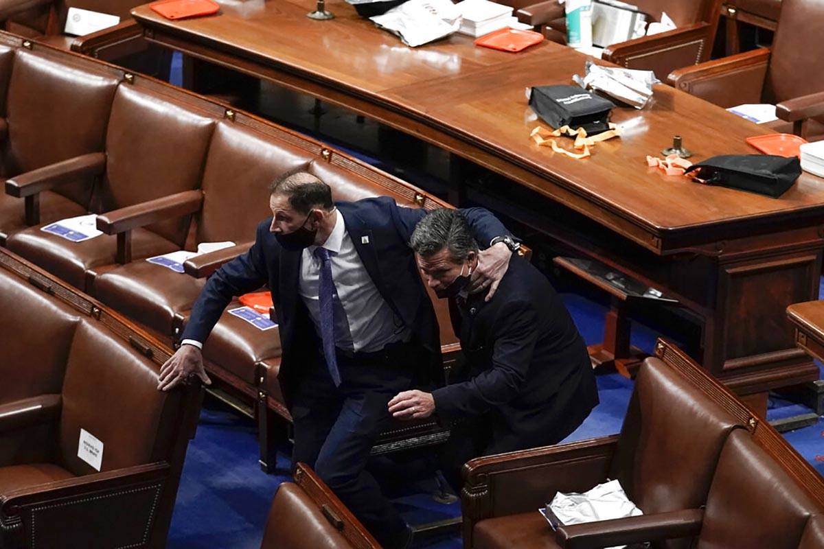 Lawmakers evacuate the floor as protesters try to break into the House Chamber at the U.S. Capi ...