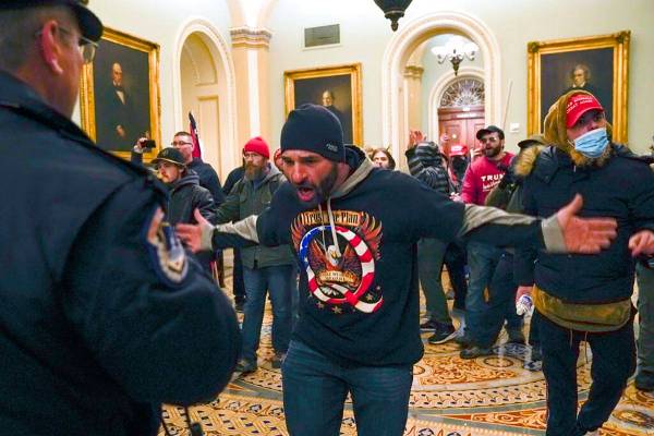 Trump supporters gesture to U.S. Capitol Police in the hallway outside of the Senate chamber at ...