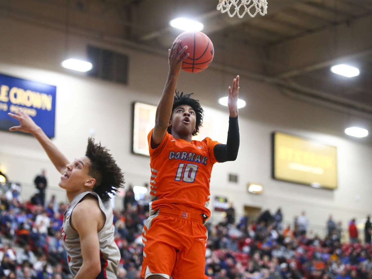 Bishop Gorman's Zaon Collins (10) goes to the basket in front of Findlay Prep's Blaise Beaucham ...